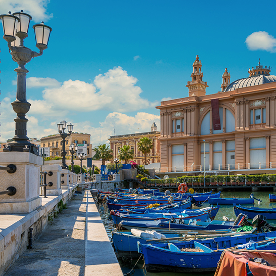 Angedockte Boote mit dem Margherita-Theater im Hintergrund, Bari, Apulien, Süditalien.
