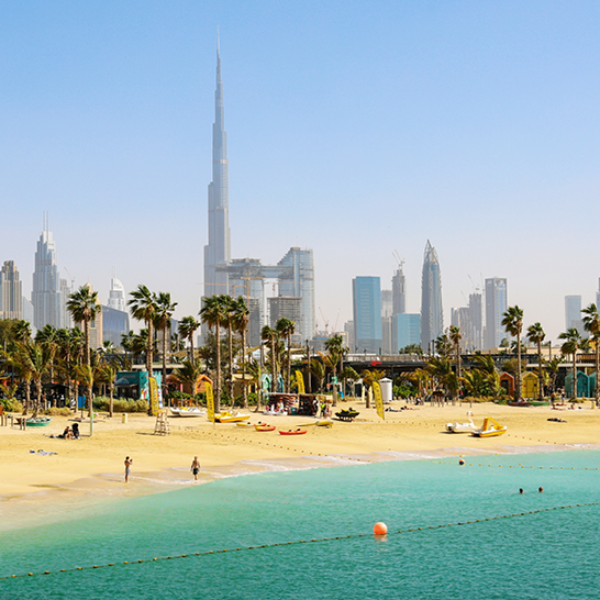 Dubai Strand La Mer, Menschen ruhen sich aus, in der Ferne die Wolkenkratzer der Stadt. Vereinigte Arabische Emirate Dubai März 2019.