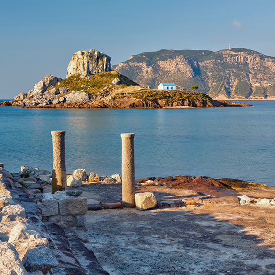 Blick auf eine felsige Küste mit einer kleinen Insel im Hintergrund, griechische Insel Kos.