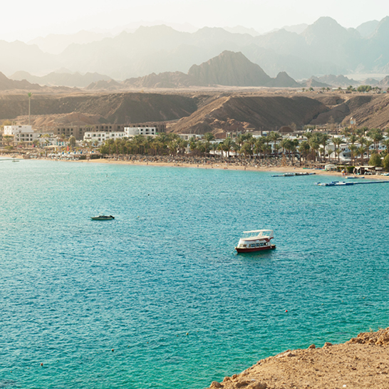 Ein Blick auf das Wasser von Hurghada Sharm El Naga mit Booten, die sanft darauf schwimmen.