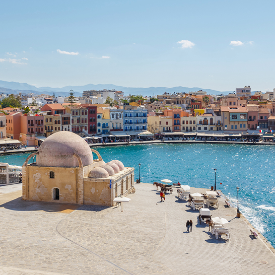  Blick auf die Stadt Chania auf Kreta mit einem grossen Gewässer im Vordergrund.