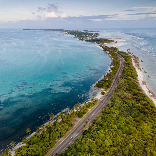 Aus der Vogelperspektive: tropische Strände und lokale Wege in Addu City, dem südlichsten Atoll der Malediven. Perfekt für unvergessliche Ferien auf den Malediven.