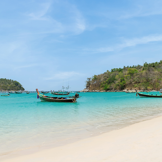 Kata Beach mit kristallklarem Wasser und traditionellem Holzboot, berühmtem Urlaubsziel und Feriengebiet, Phuket, Thailand
