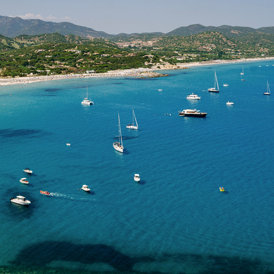 Ein grosser Wasserbereich in Villasimius, Sardinien, mit ruhigem, blauem Wasser und umgebenden Küstenlinien.