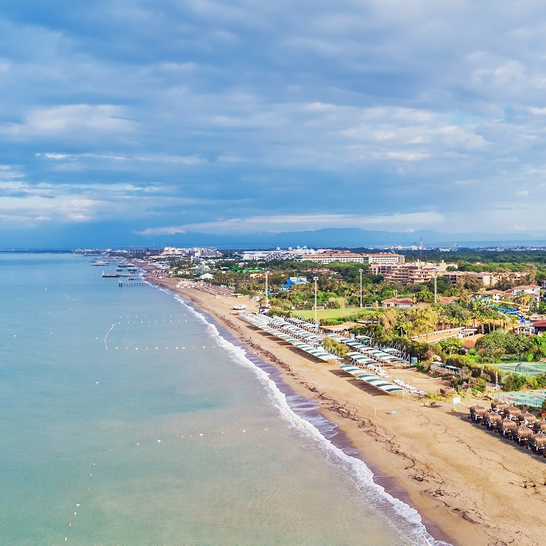 Luftaufnahme eines Strandes und Resortbereichs in Belek, ideal für Badeferien und Entspannung.