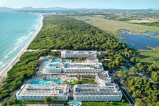 Luftaufnahme des Iberostar Selection Albufera Playa. Das Resort ist umgeben von Grünfläche und grenzt an einen langen Sandstrand