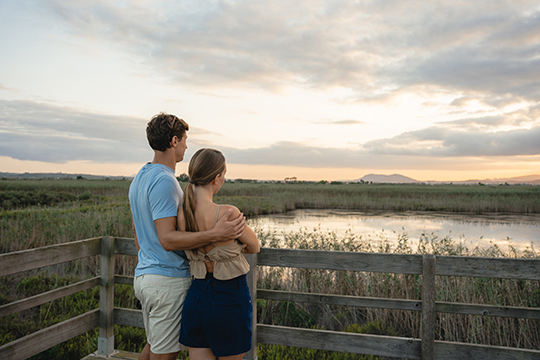 Ein Päärchen beobachtet von einer Aussichtsplatform aus die vielen Vogelarten welche sich im nahegelegenen Naturpark befinden